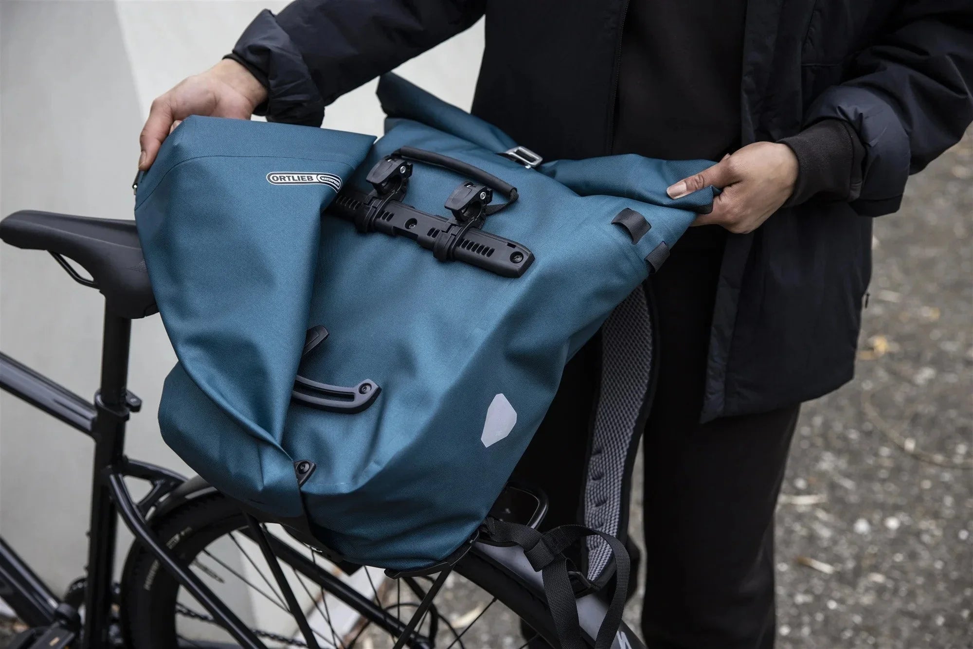 Person closing a bicycle pannier.
