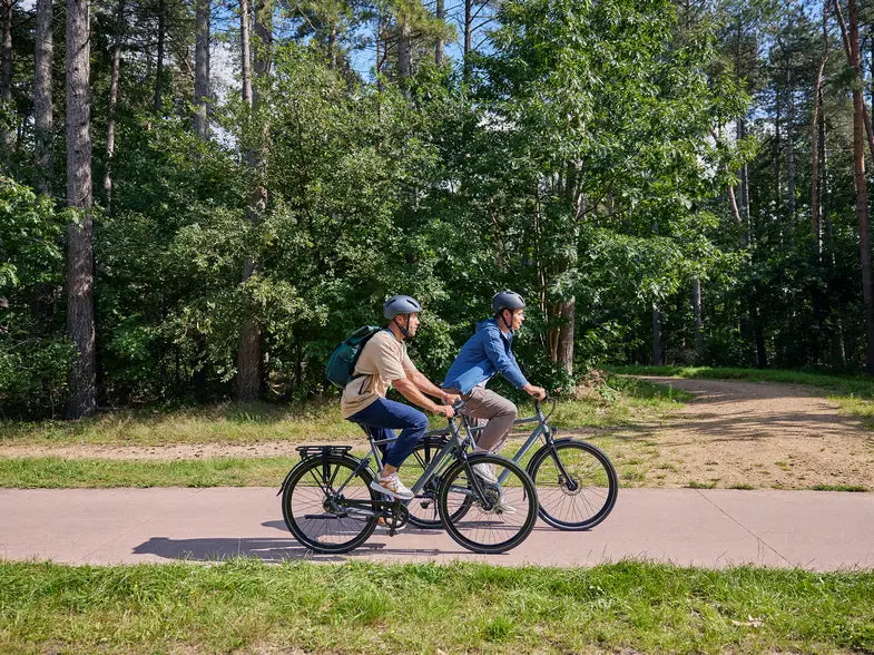 Men riding a hybrid electric bicycle in an urban environment.