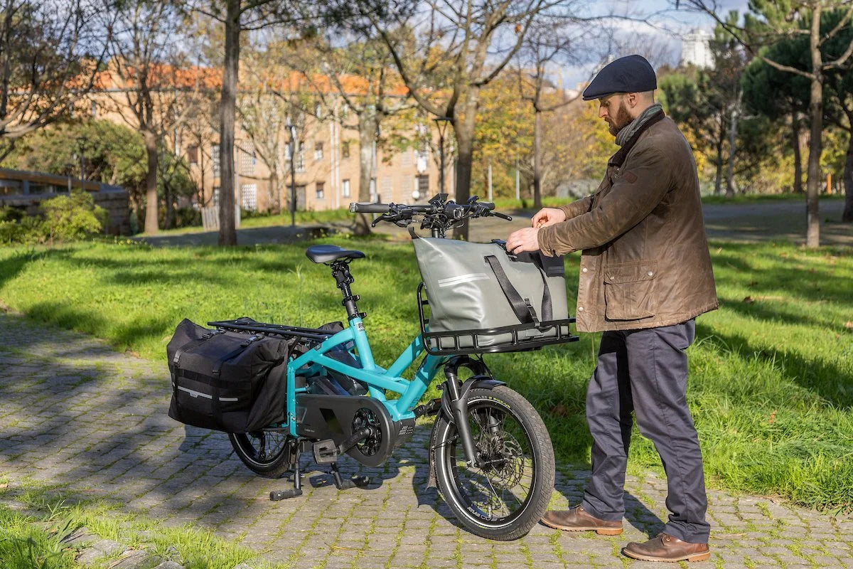 Man with a teal electric bike in a park