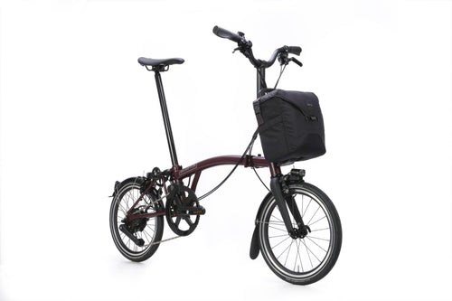 Brompton folding bicycle with a black bag on a white background