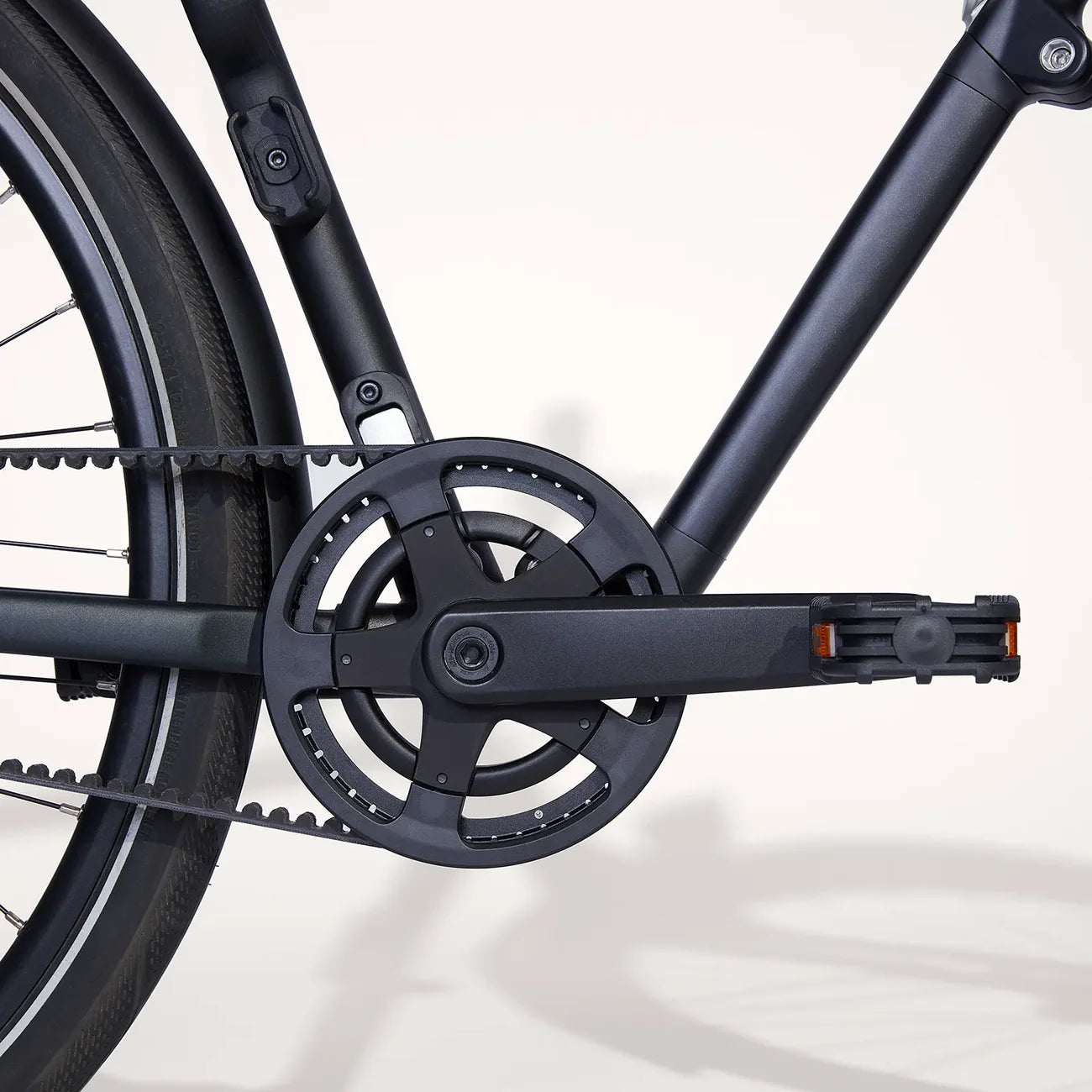 Close-up of a bicycle belt drive and gear system on a white background