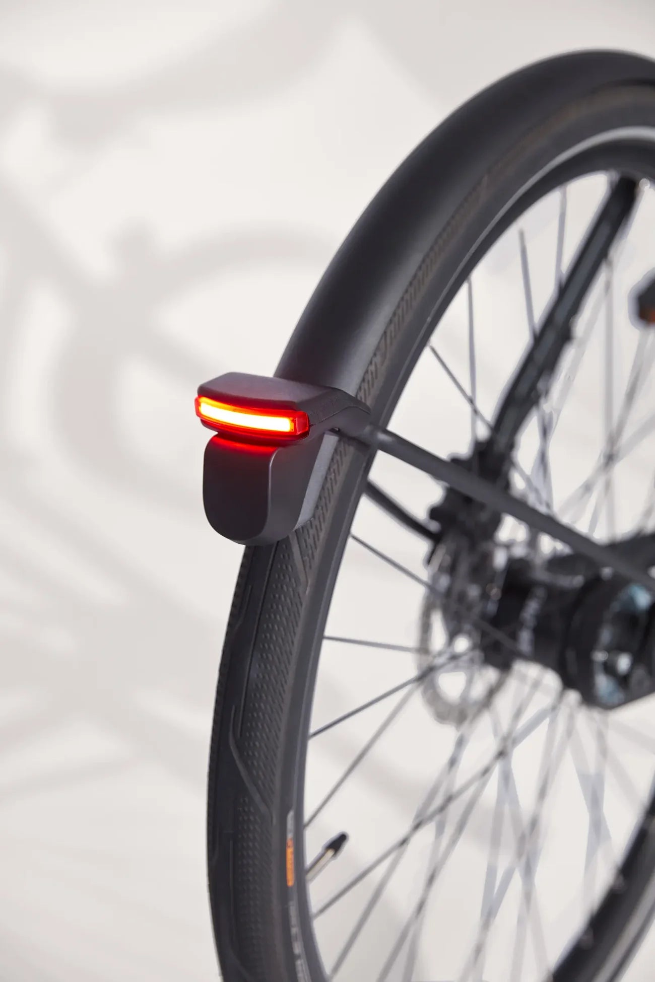 Bicycle wheel with a red taillight on a blurred background