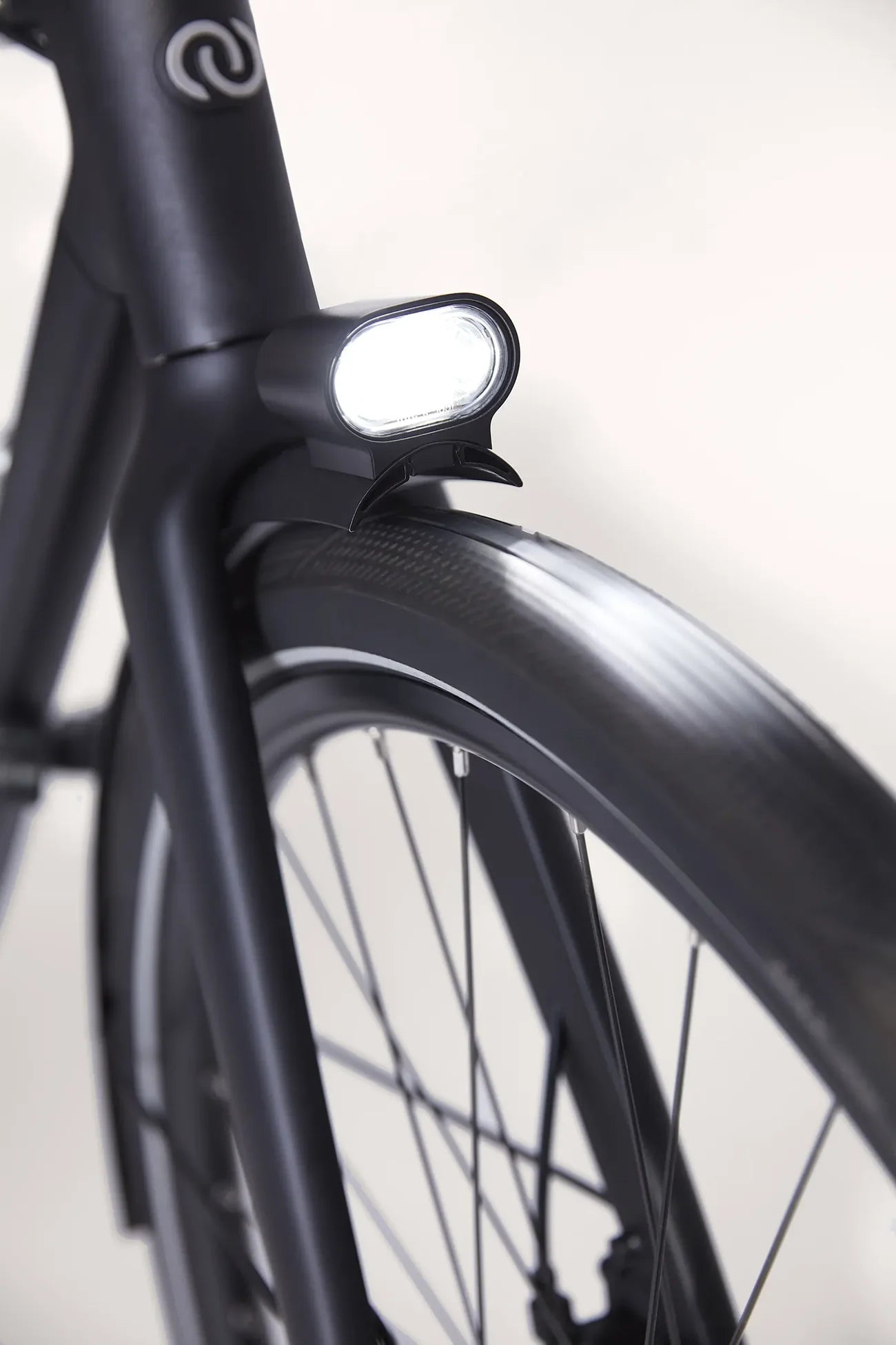Close-up of a black bicycle frame with a light on a white background