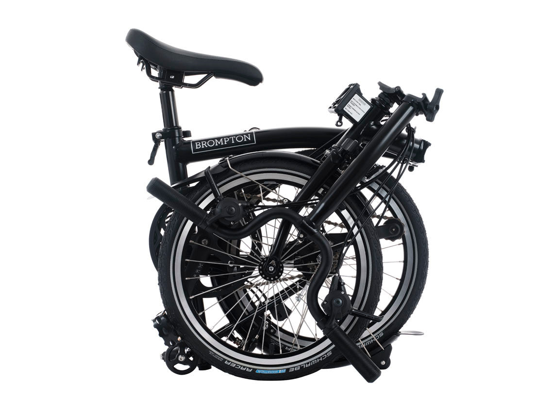 Folded black bicycle with 'Brompton' branding on a white background