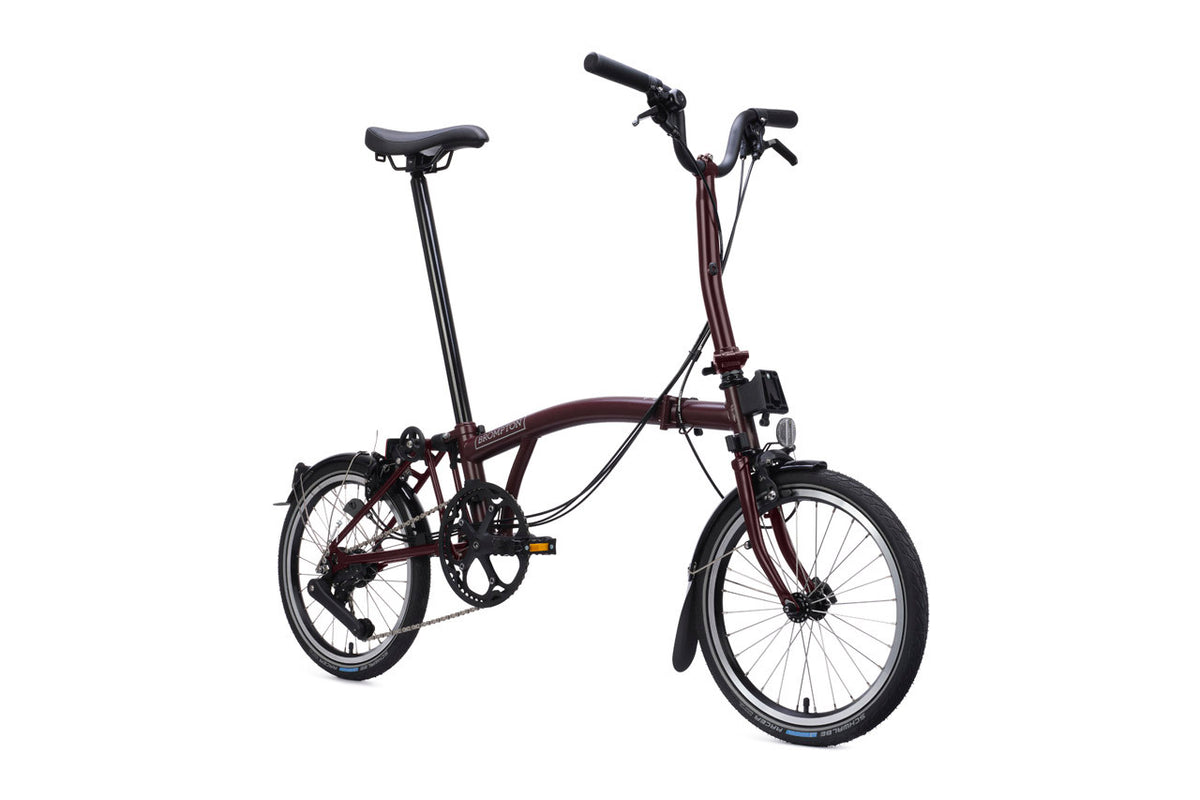 Brompton Plum red Foldable bicycle on a white background