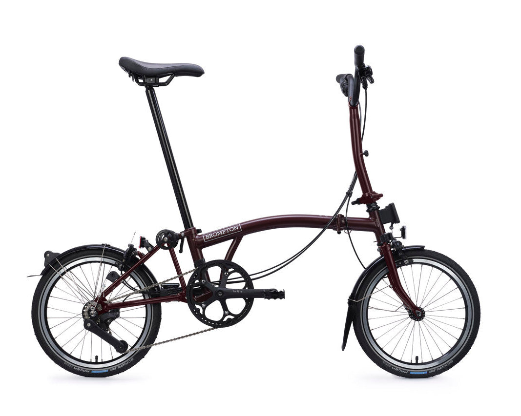Plum Red Brompton folding bicycle on a white background