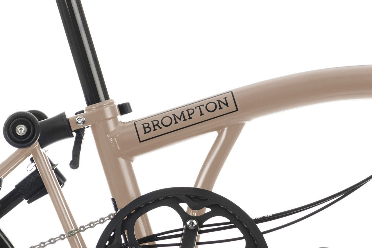 Close-up of a Brompton bicycle frame with branding on a white background