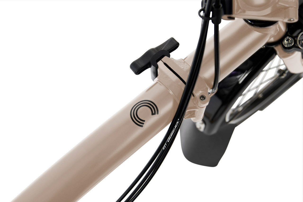 Close-up of a beige bicycle with a black logo on a white background