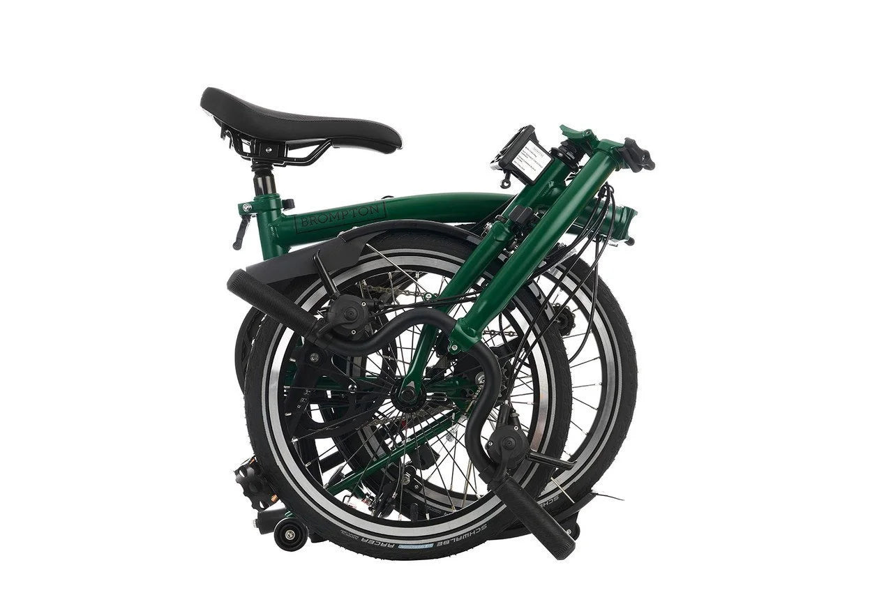 Folded Brompton green bicycle on a white background
