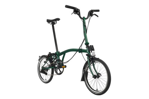 Green Brompton folding bicycle on a white background