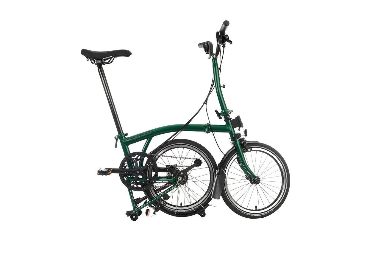 Green Brompton folding bicycle on a white background