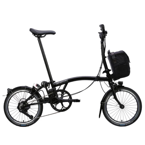 Black Brompton folding bicycle with a basket on a white background