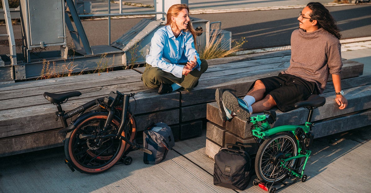 Two people with Brompton folding bikes.