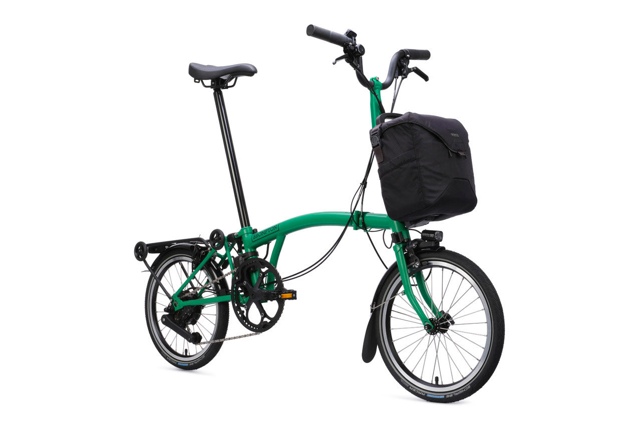 Green folding bicycle with a black bag on a white background
