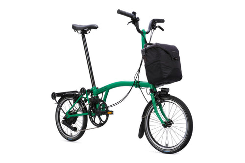 Green folding bicycle with a black bag on a white background