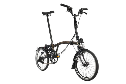 Brown Brompton folding bicycle on a white background