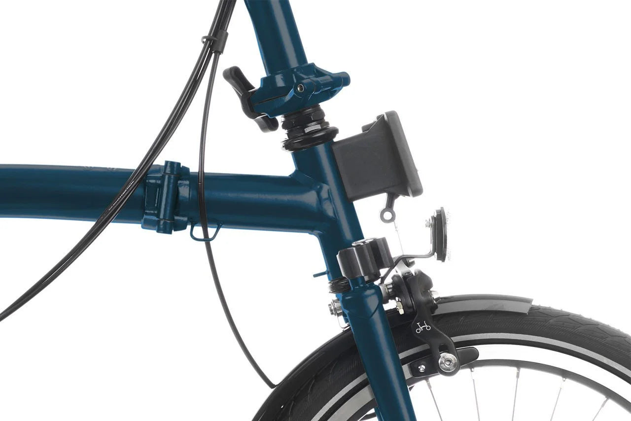 Close-up of a blue Brompton bicycle frame with a white background
