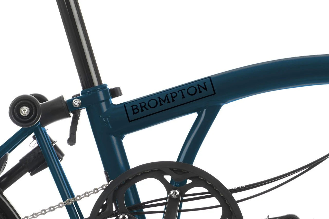 Close-up of a blue Brompton bicycle frame on a white background