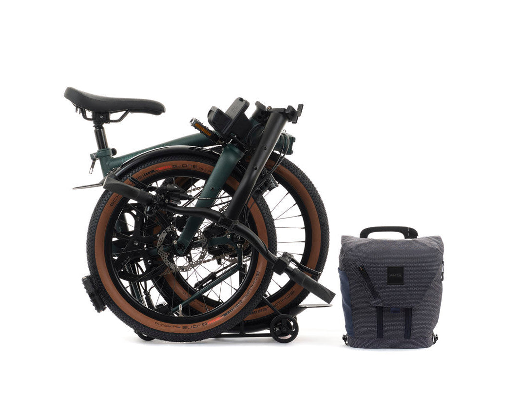 Forest Green Brompton G Line folded bike with a grey bag on the white background.