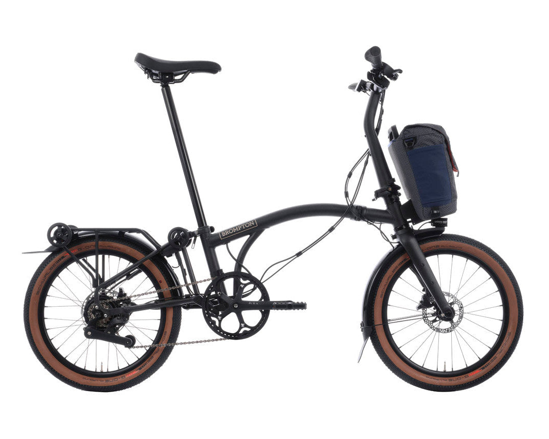 Black Brompton g Line electric folding bicycle with a blue bag on a white background