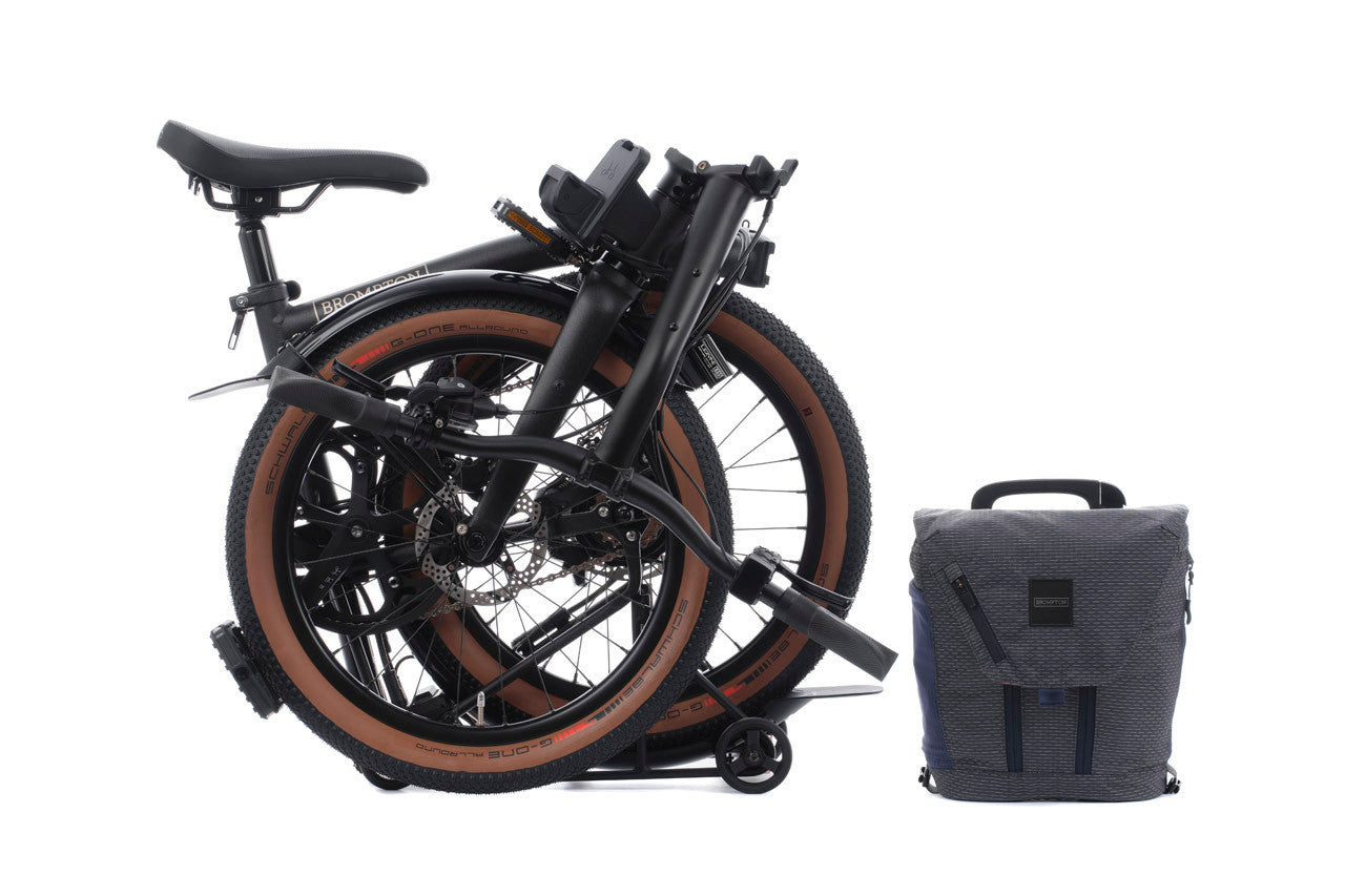 Brompton G Line Electric folded bike with grey bag on the white background.