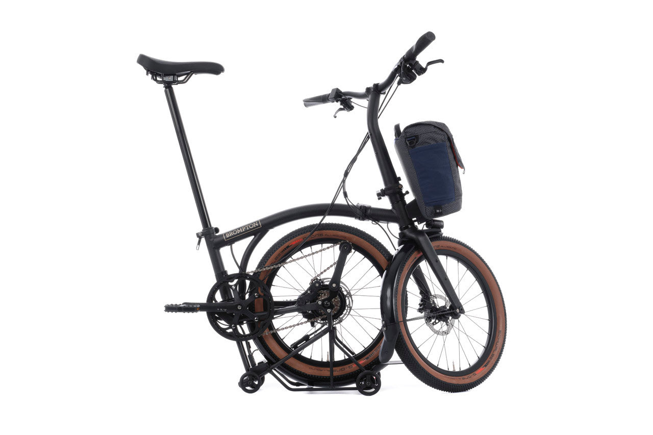 Brompton G Line Electric half folded bike with grey bag on the white background.