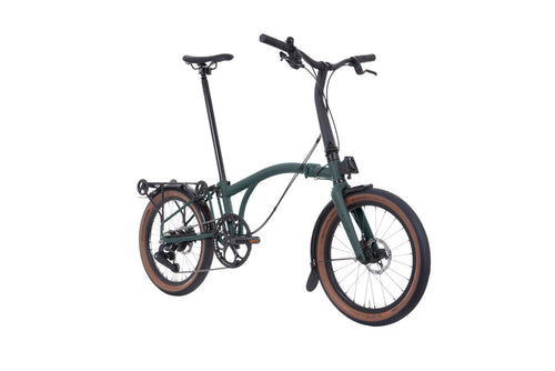 Green Brompton folding bicycle on a white background