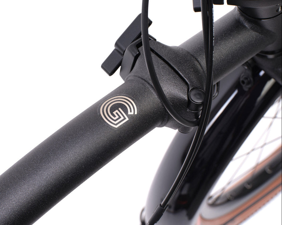 Close-up of a Brompton G Line bicycle frame with a brand logo on a white background