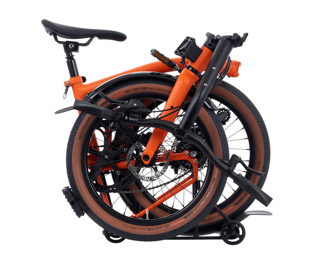 Orange Brompton G Line folding bicycle on a white background