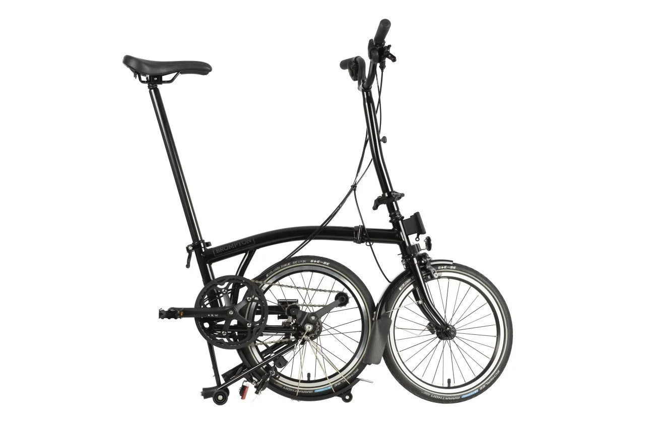 Black Brompton folding bike on the white background.