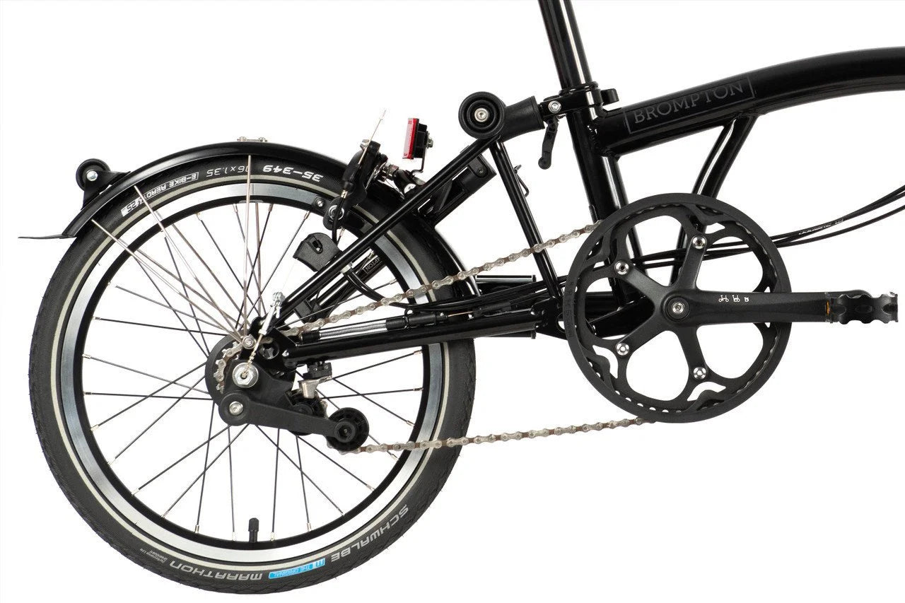 Black Brompton folding bike on the white background. back of the bike showing drivetrain.