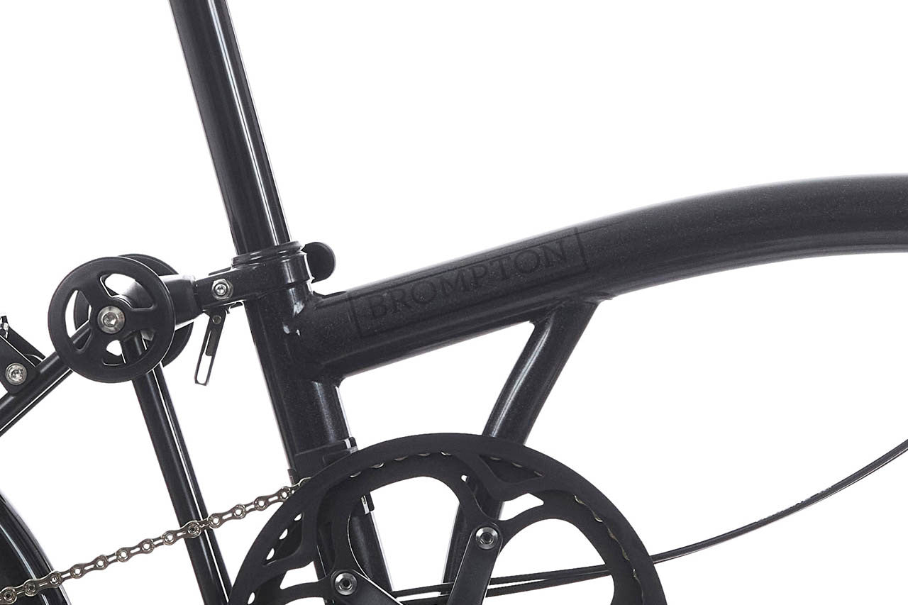 Close-up of a black bicycle frame with 'Brompton' branding on a white background