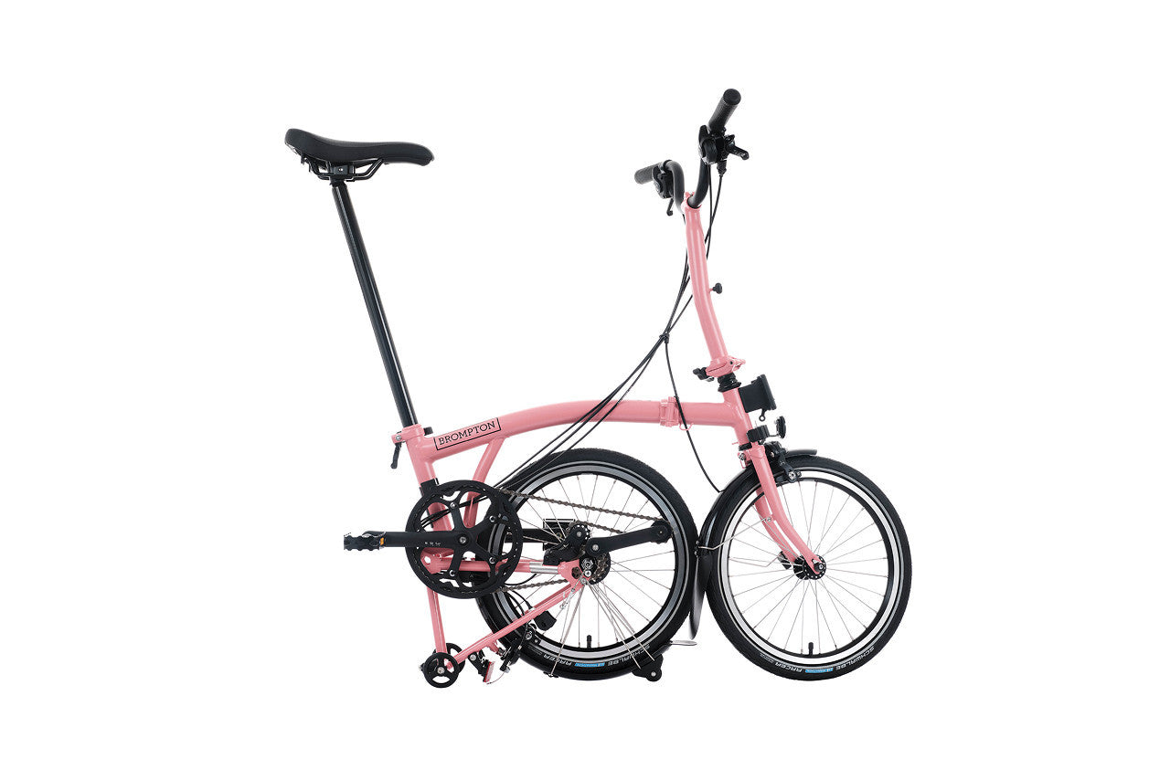 Brompton c Line pink folding bike on white background.