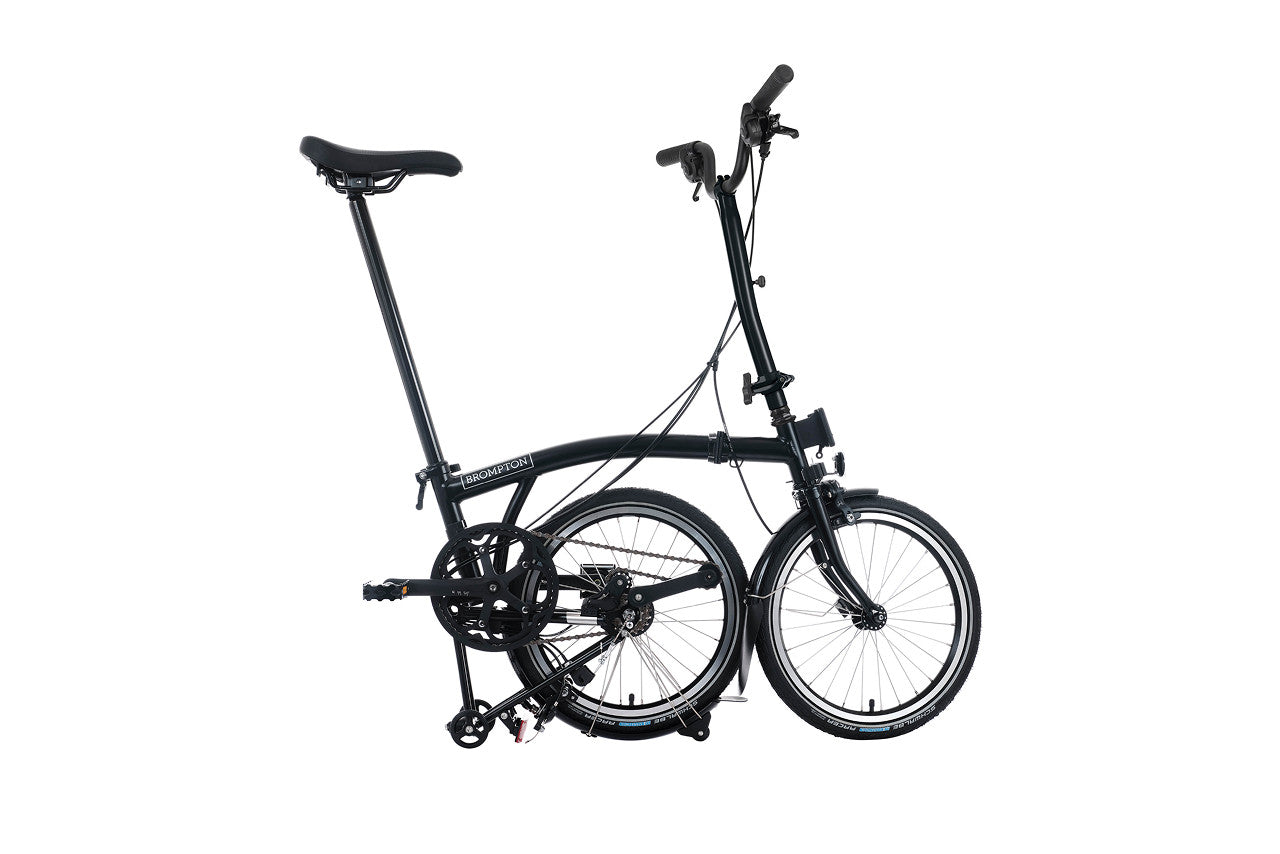 Black Brompton folding bicycle on a white background