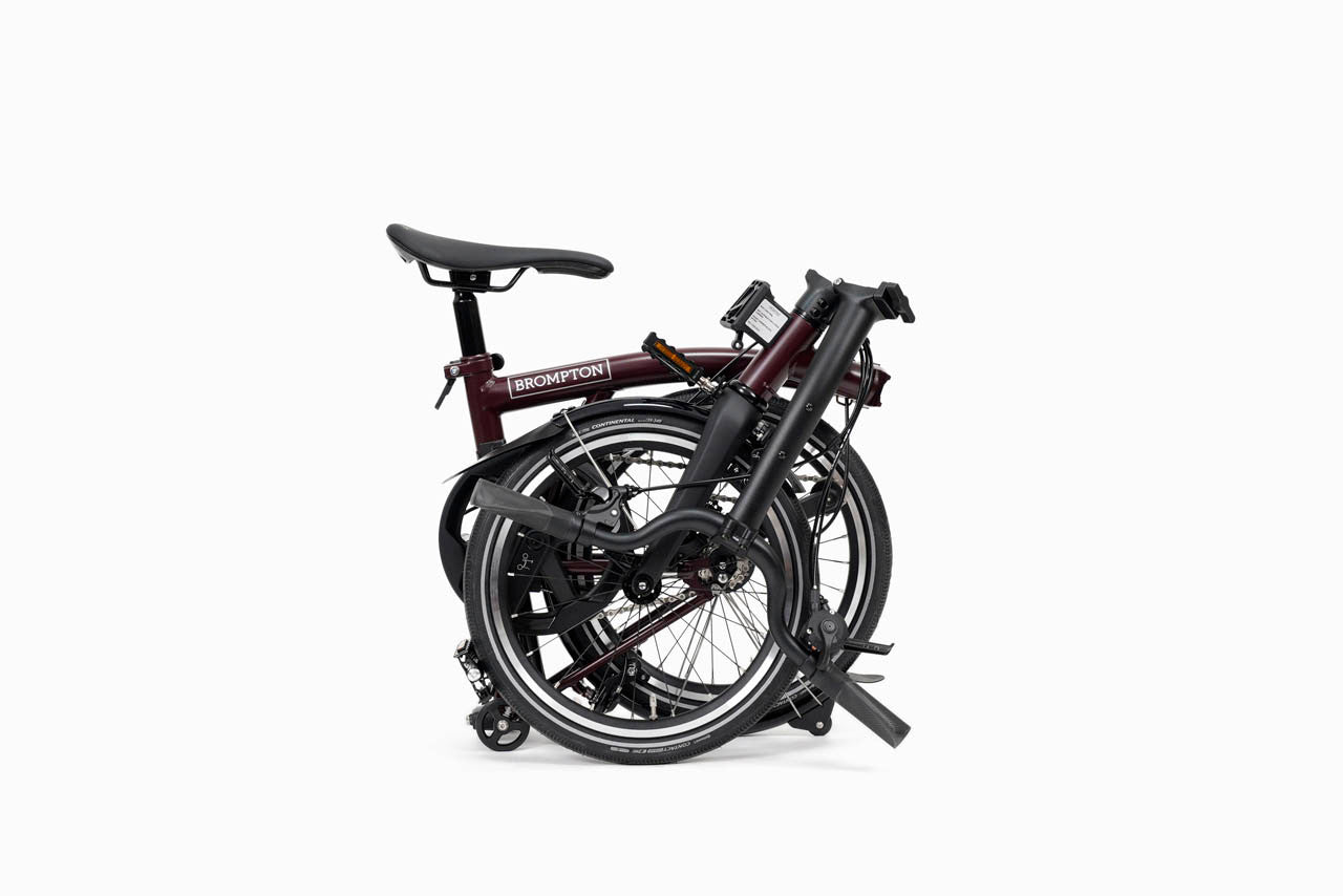 folded Purple brompton p line folding bicycle on a white background