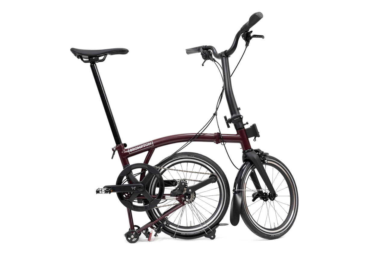 Half folded Purple brompton p line folding bicycle on a white background