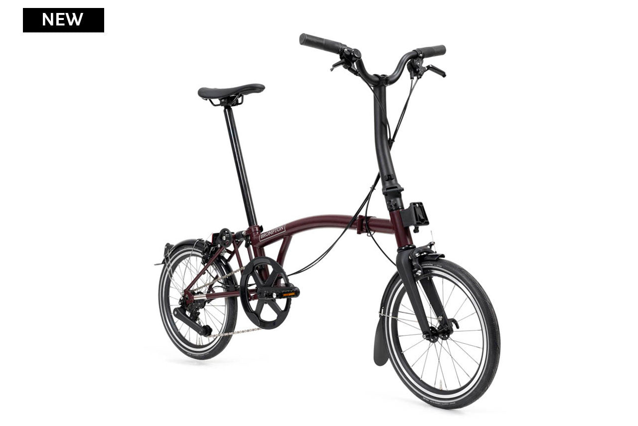 Purple brompton p line folding bicycle on a white background
