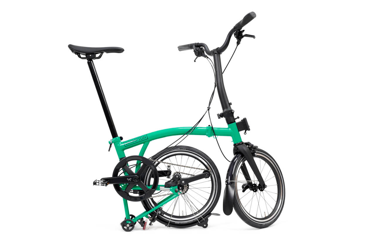 Green folding bicycle on a white background