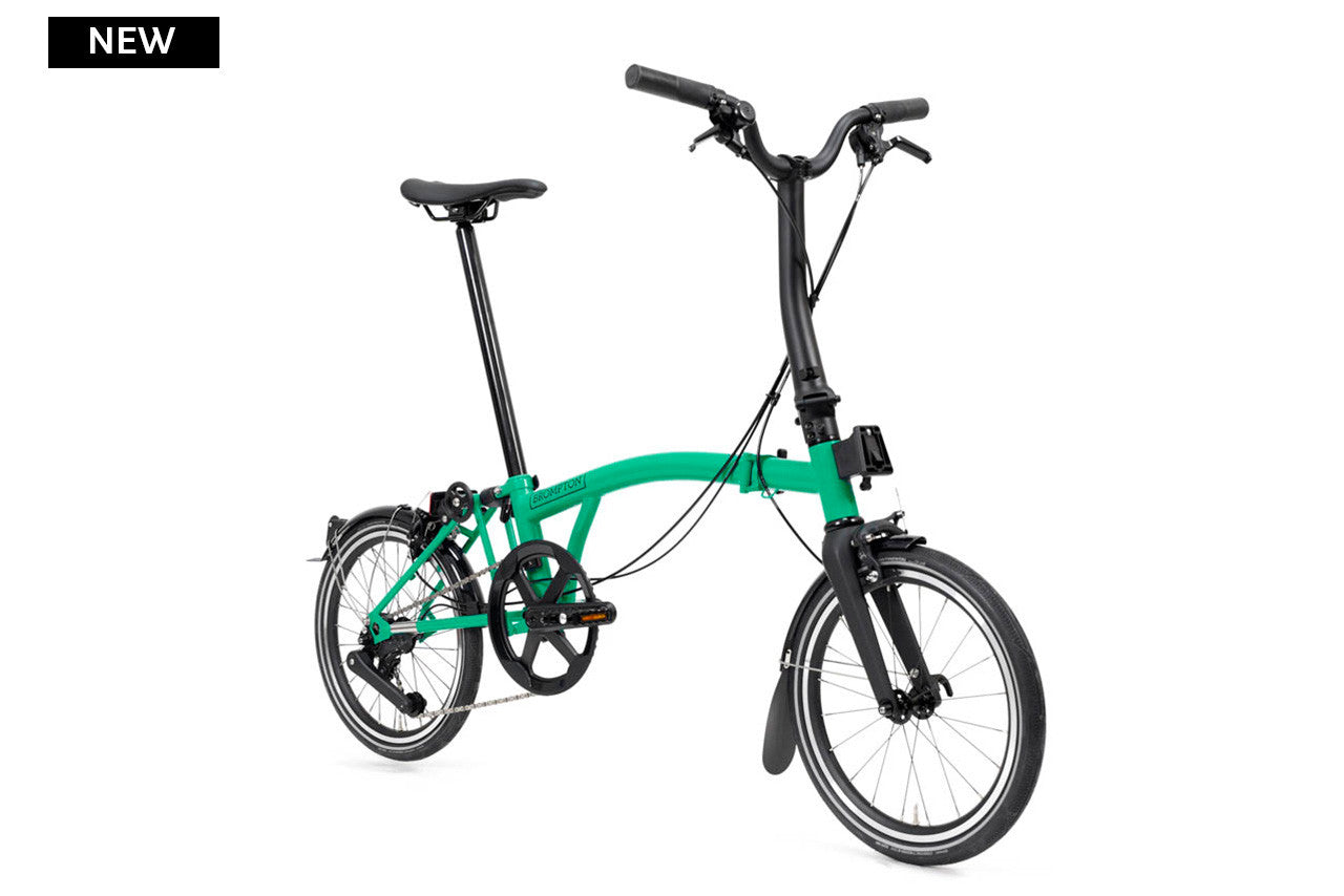 Green folding bicycle on a white background