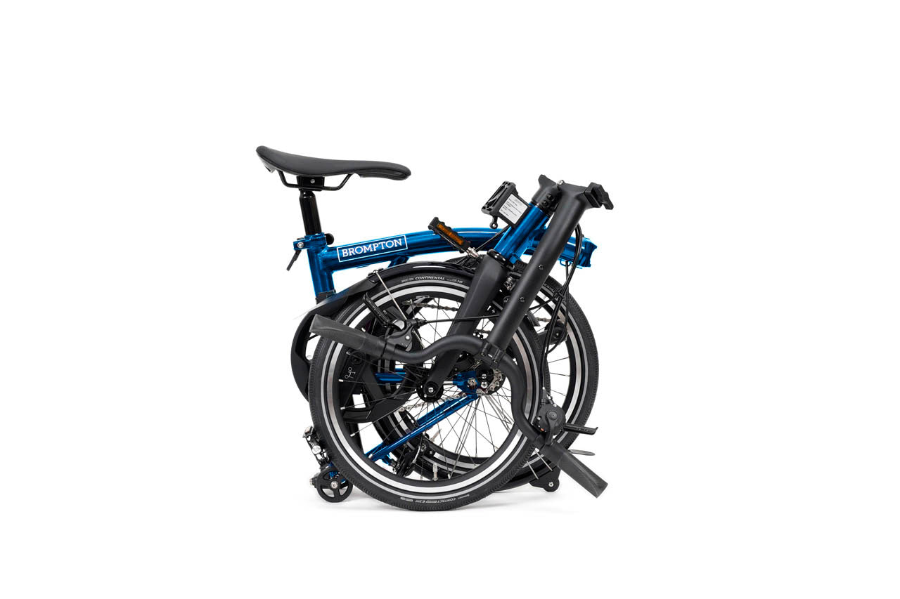 Folded blue brompton p line bicycle on a white background