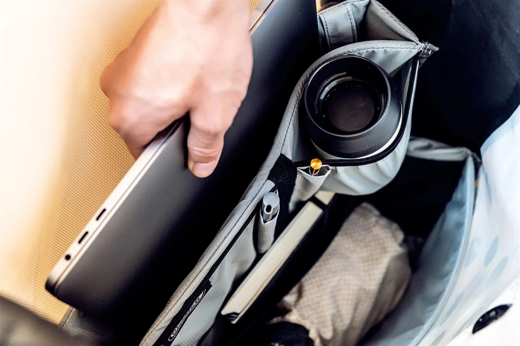 Hand placing a laptop into a pannier bag.