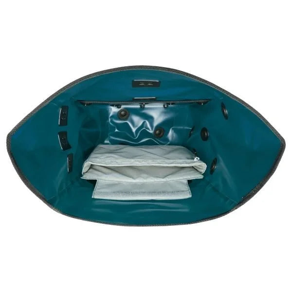 Teal bike pannier interior with a white cloth inside on a white background