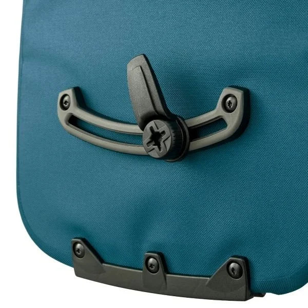 Close-up of a blue pannier bag with a black handle and metal clasps on a white background