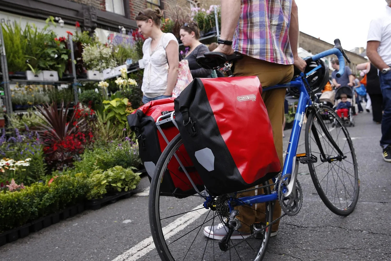 Ortlieb pannier bags on a blue bicycle.