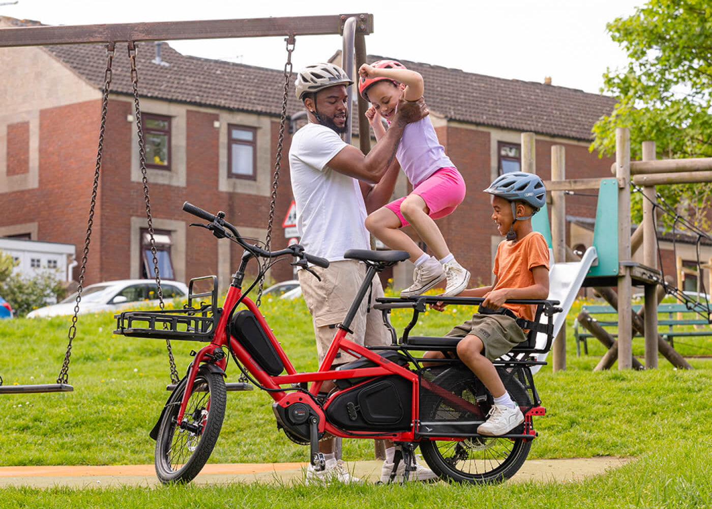 Family with a red electric bike at a playground