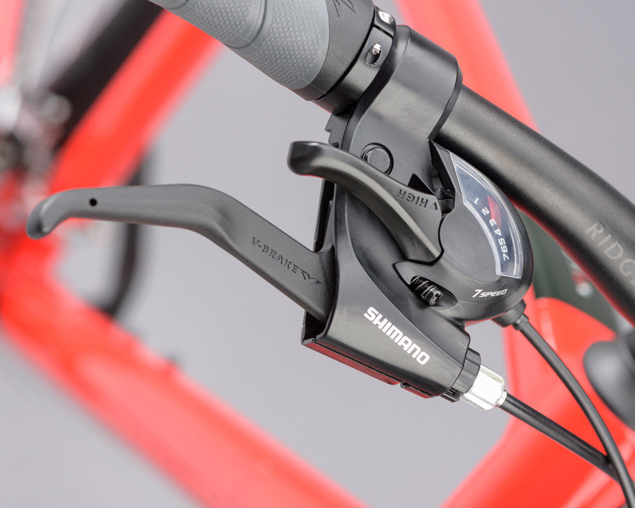 Close-up of bicycle handlebars with Shimano components on a blurred grey background