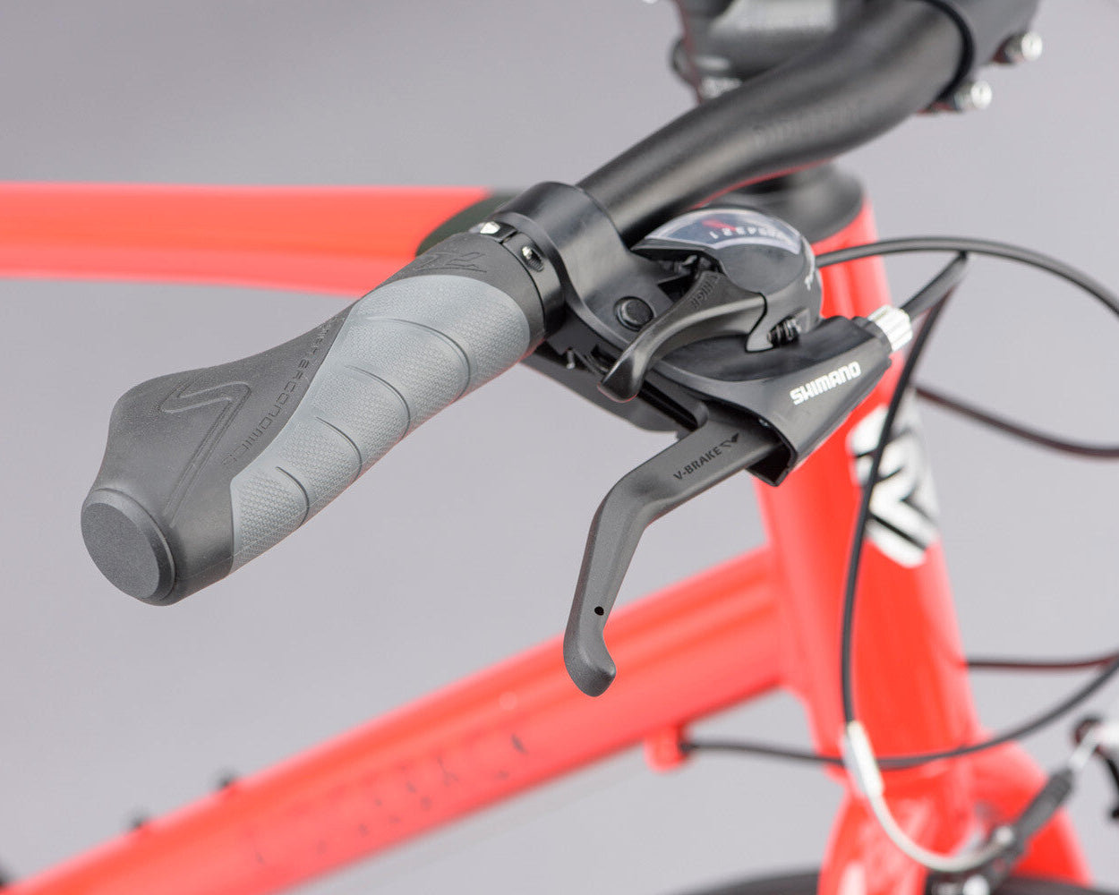 Close up of bicycle grips and brake lever on a grey background.