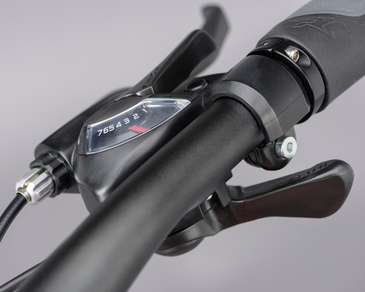 Close up of a bicycle gear shifter on a grey background.