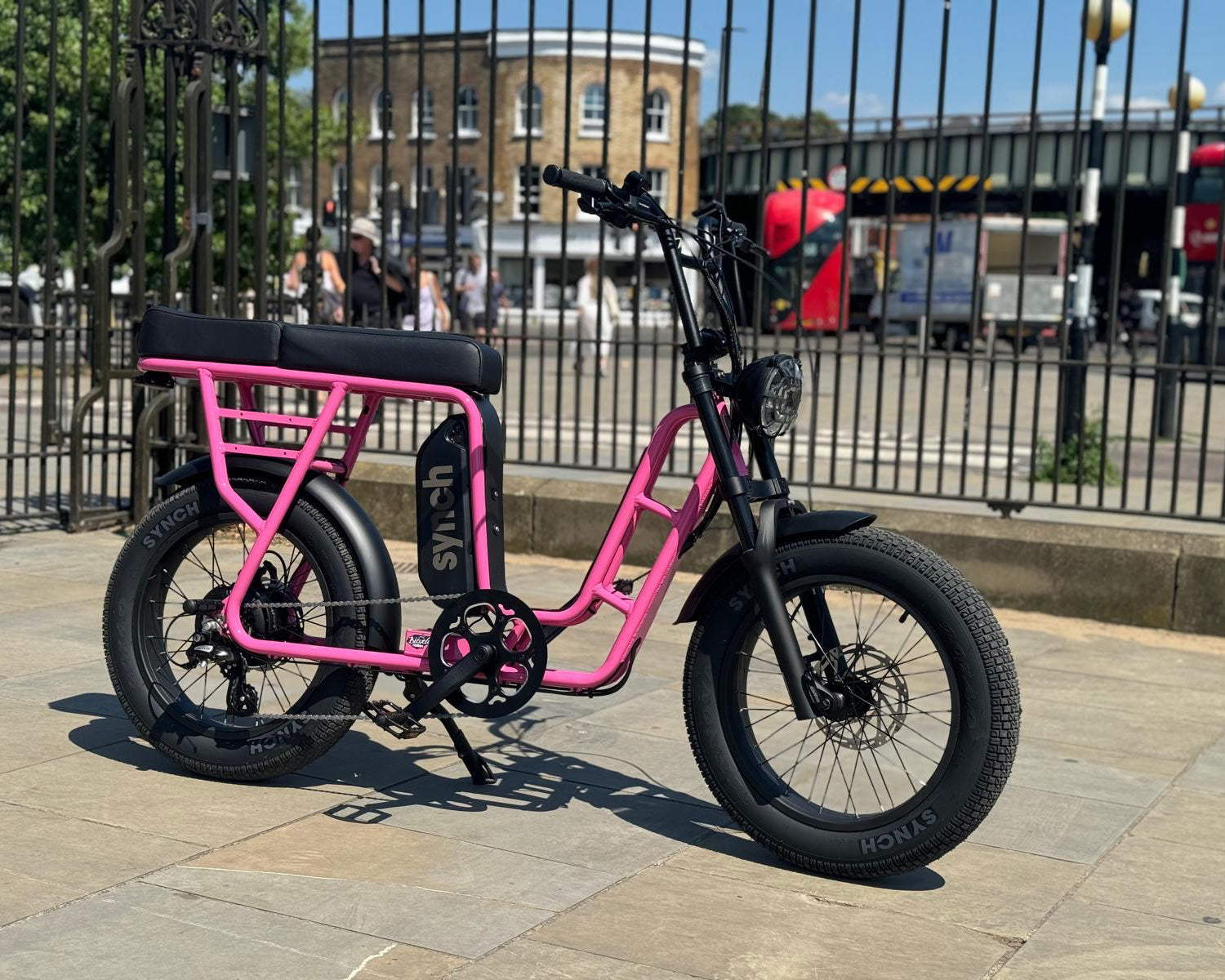 Pink Synch Electric bicycle in the city setting.
