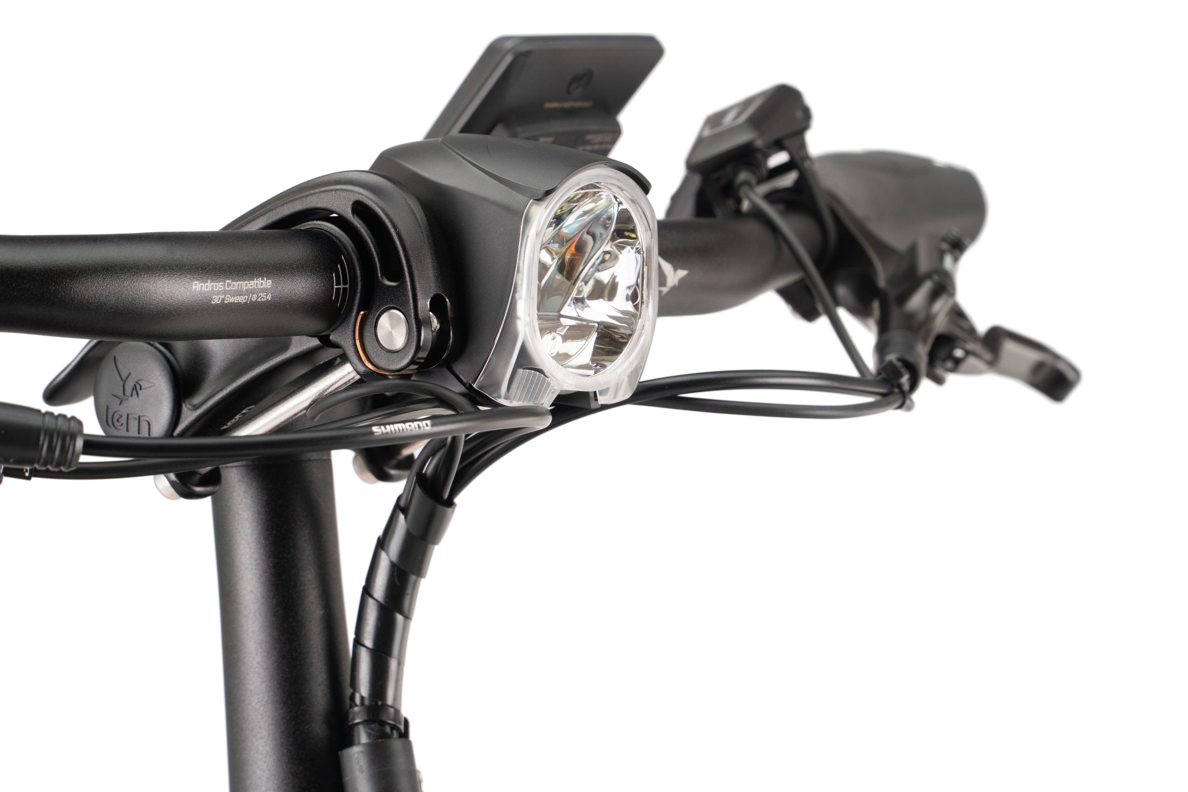 Close-up of a bicycle handlebar with a headlight and control panel on a white background